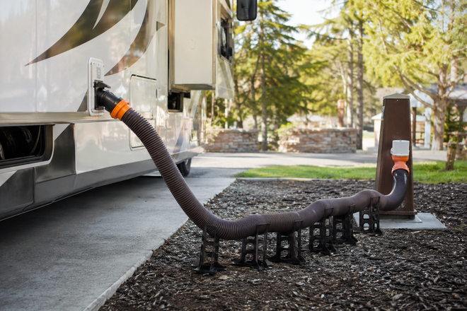 RV sewer hose and support connected at a full-hookup campsite